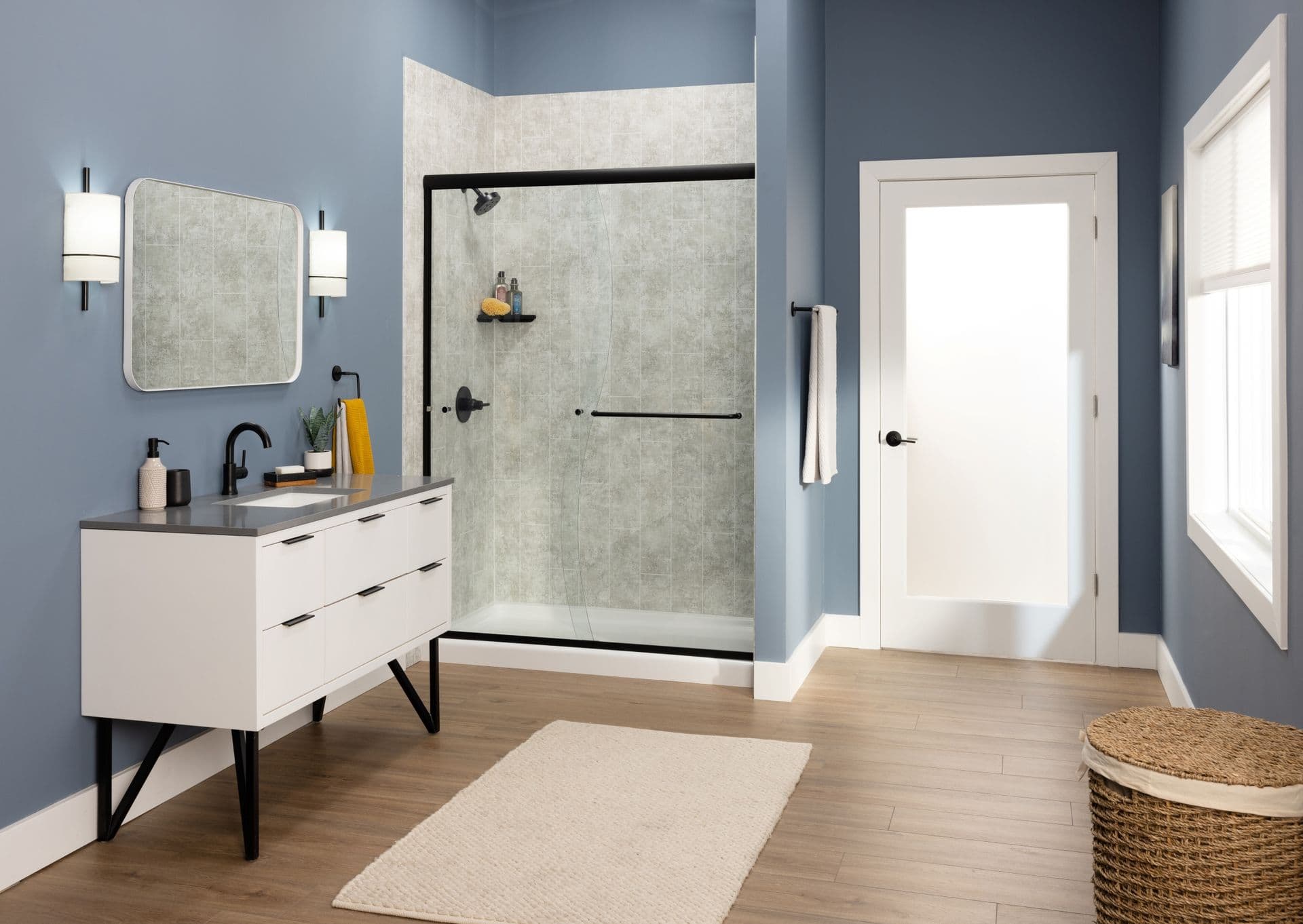 A blue bathroom with walk-in shower with sliding glass doors, vertical tile patterned walls, and black fixtures.