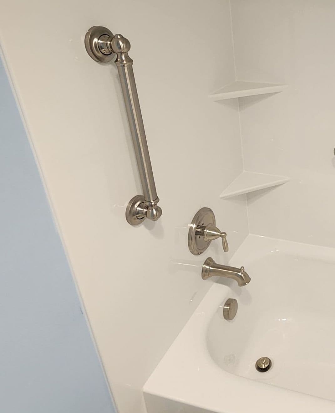 A vertical grab bar safety accessory in a combination shower tub.
