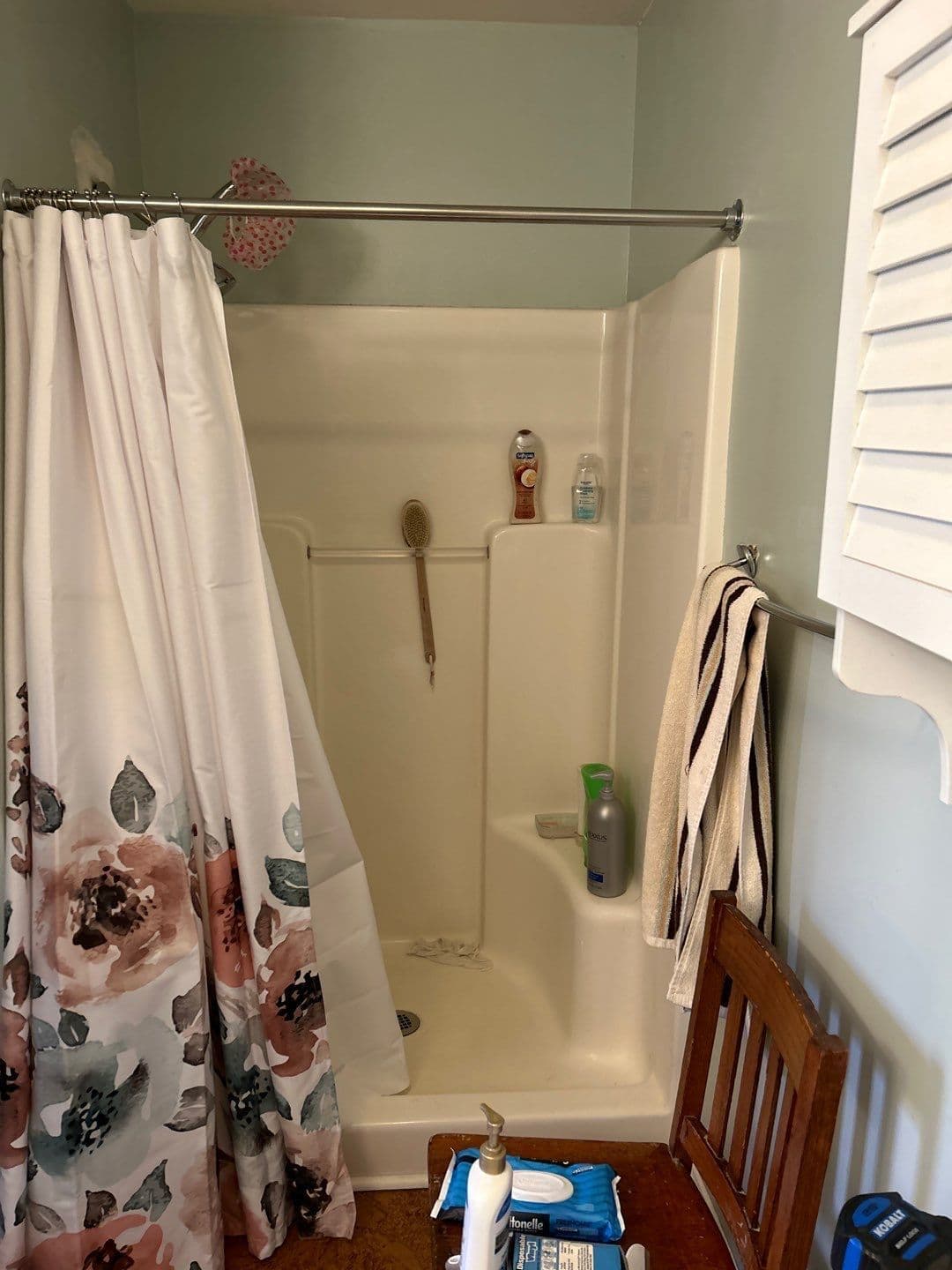 A green bathroom with a dated, beige walk-in shower.