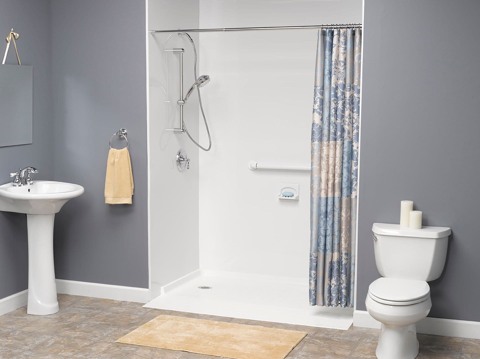 A gray bathroom with a white walk-in shower with shower curtain and safety grab bar.