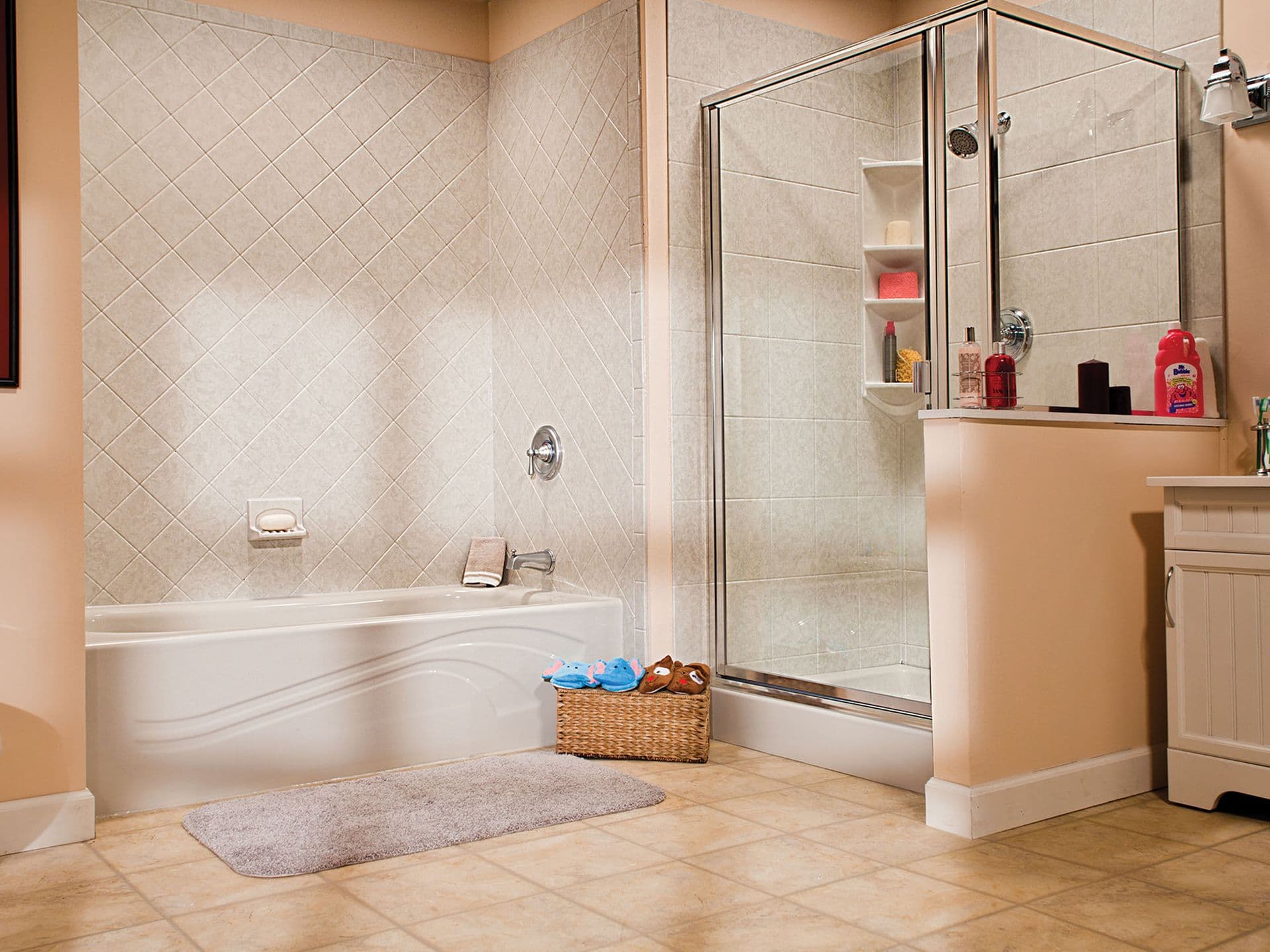A separate bathtub and shower stall with glass doors with beige-colored tile-pattern walls.