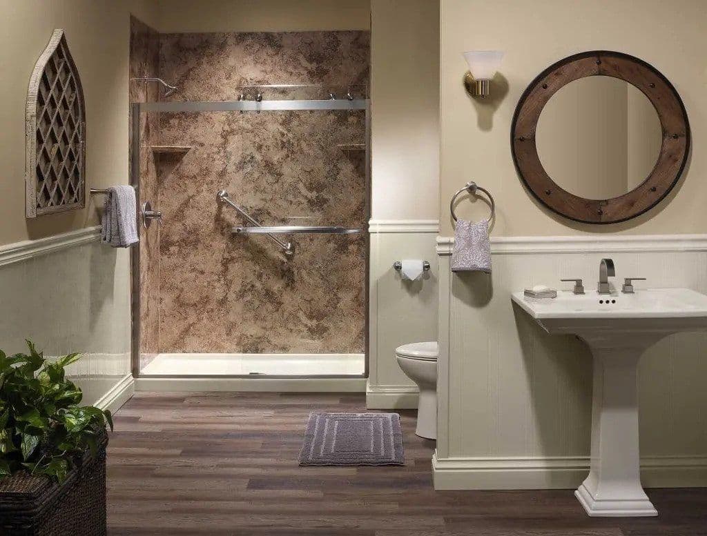 A walk-in shower with sliding glass doors, brown marbled walls, diagonal grab bar, and corner shelves.