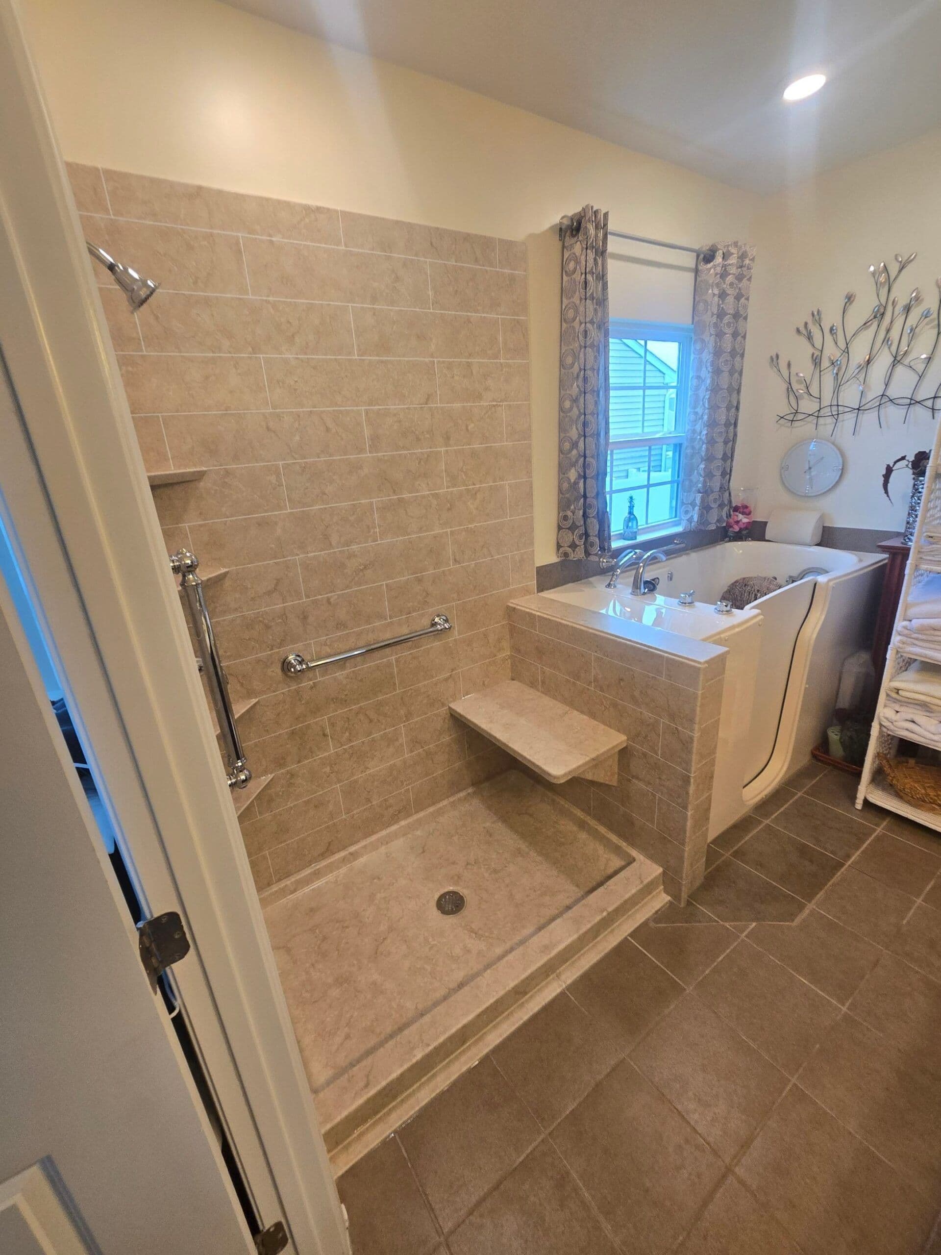 An accessible bathroom with a walk-in shower with built-in shower bench and grab bar. A walk-in tub is in the background.