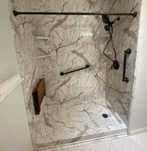bathroom with safety accessories added to it such as a grab bar and shower seat